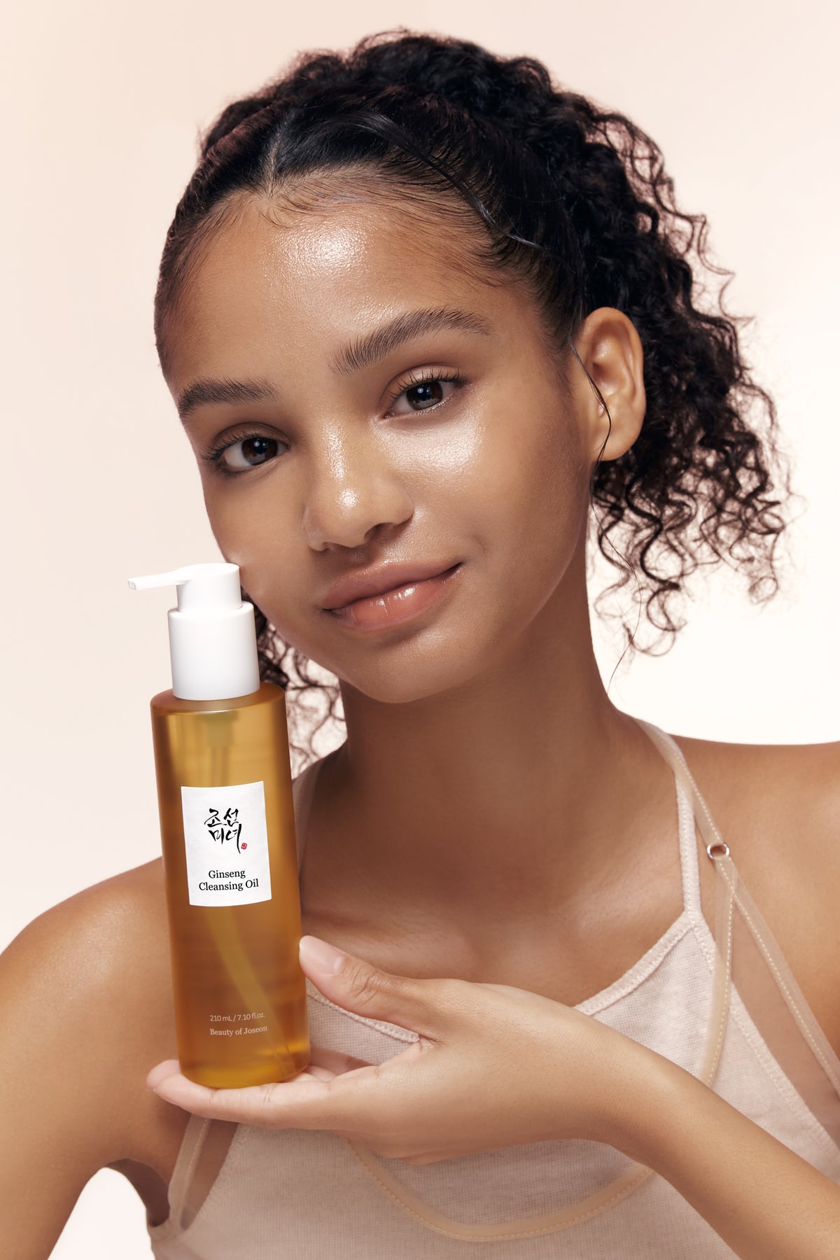 A model holding Beauty of Joseon Ginseng Cleansing Oil in her hand.