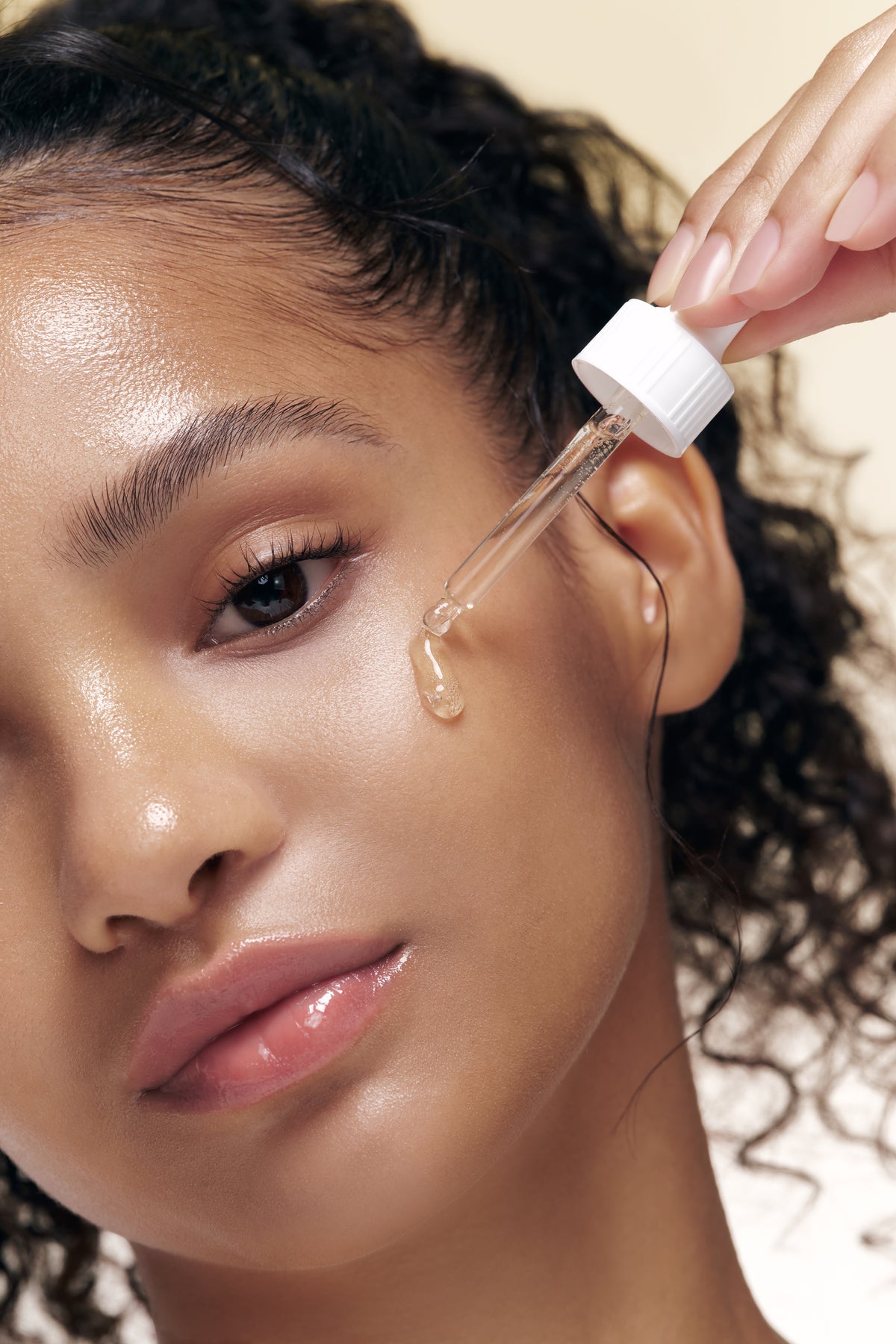 Applying Beauty of Joseon Glow Propolis Serum to the face.