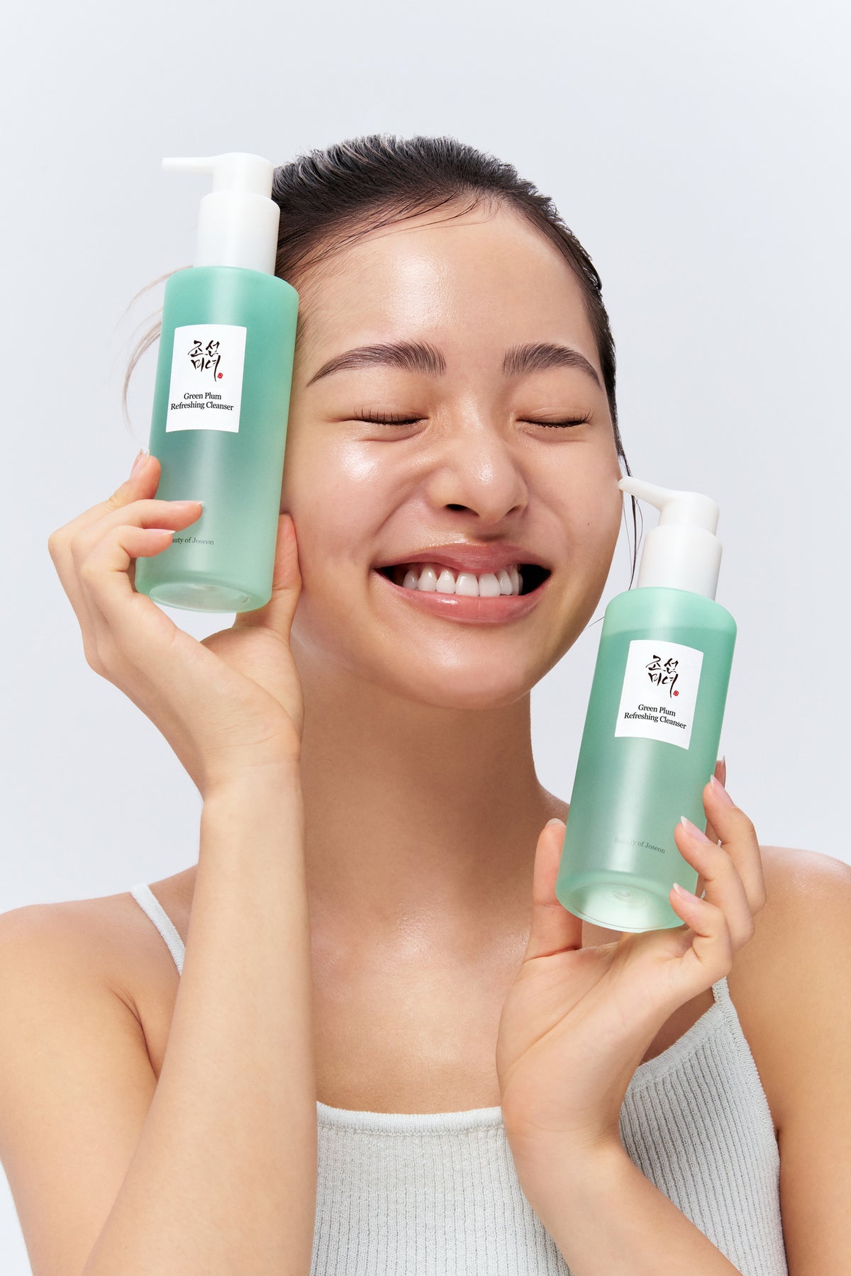 A model holding Beauty of Joseon Green Plum Cleanser in her hand.