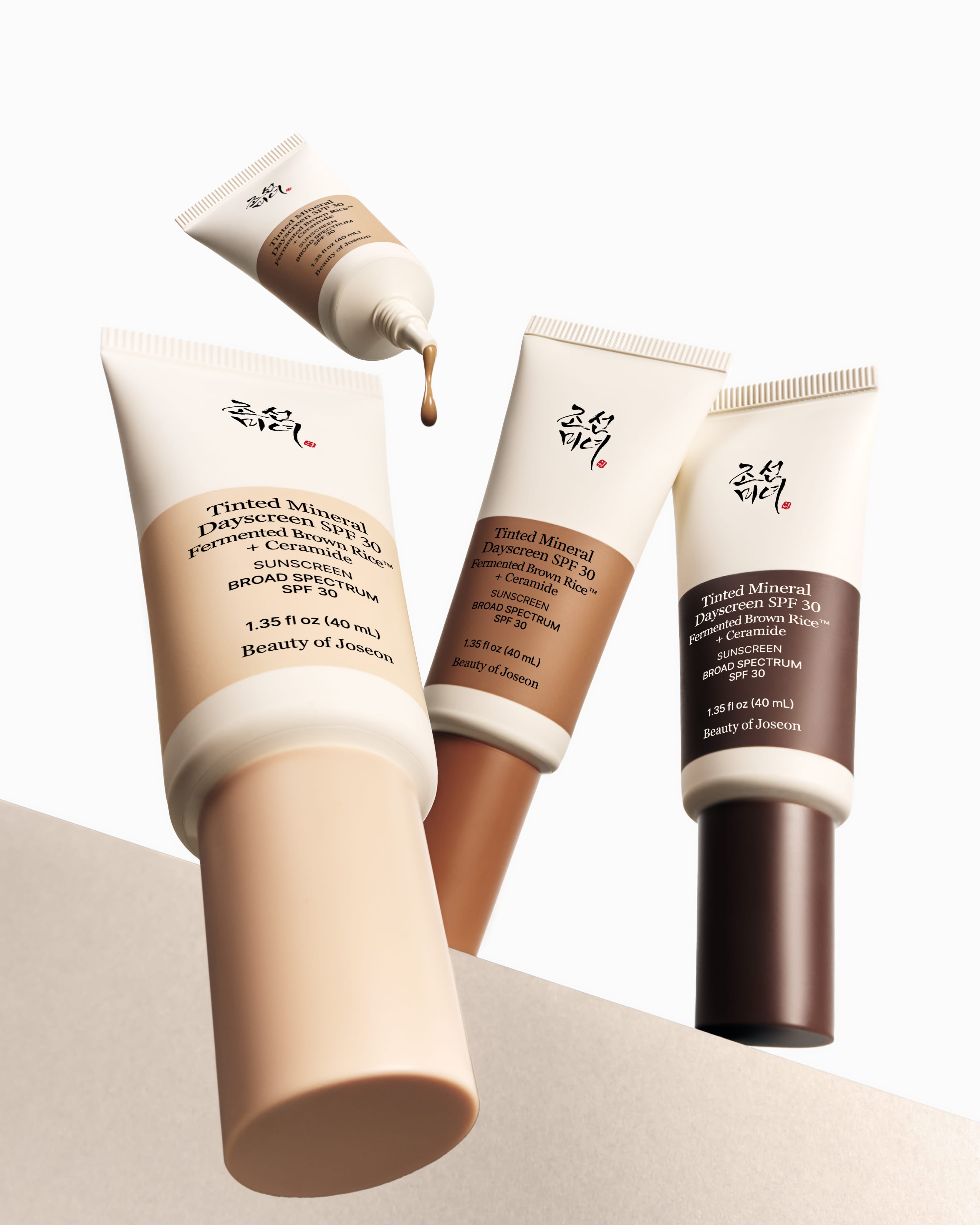 Three tubes of Beauty of Joseon Tinted Mineral Dayscreen Sunscreen on a beige background